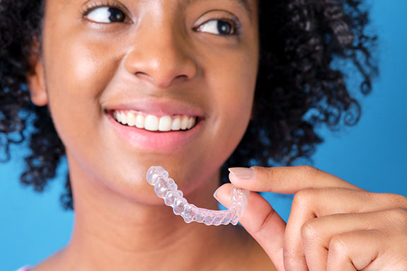 Young woman with transparent dental retainer